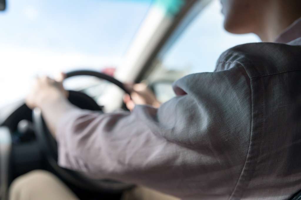 トラックを運転する男性の後ろ姿