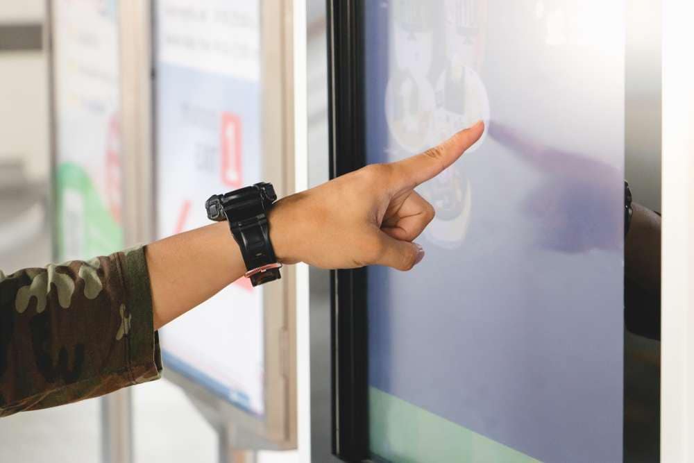 デジタルサイネージをタッチする人