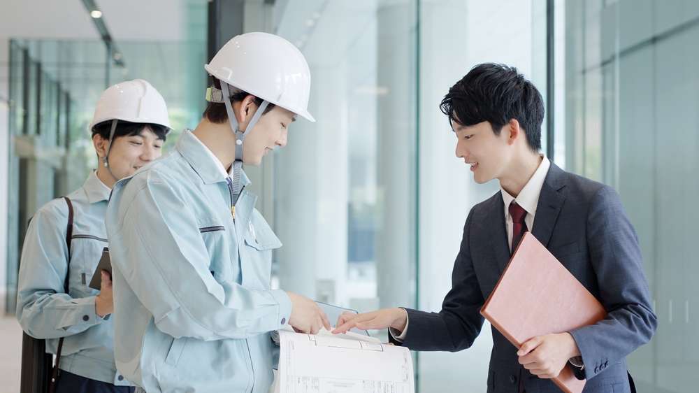 工事業者と打ち合わせをする社員