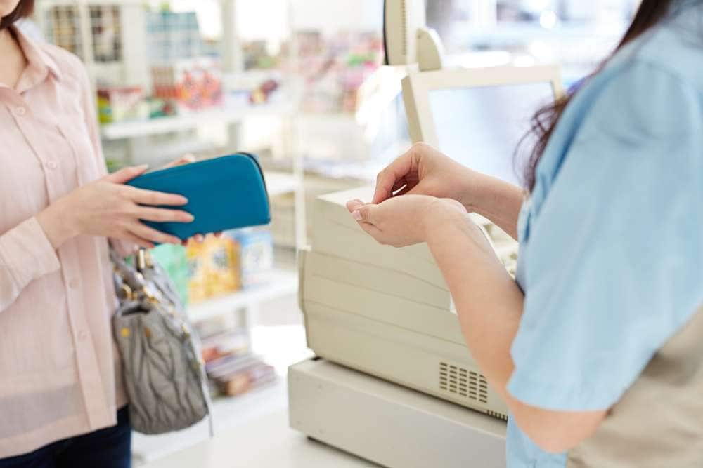 レジで接客する女性店員