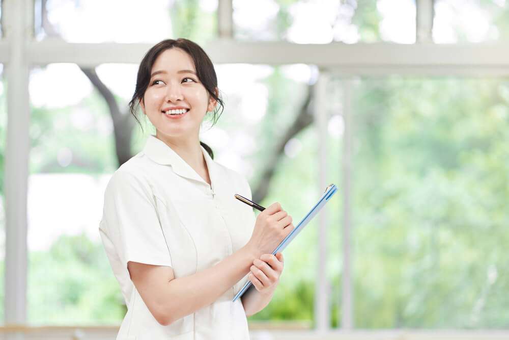 笑顔でカルテを持つ看護師
