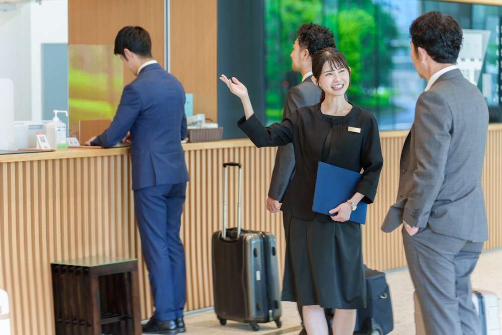 ホテルのフロントで顧客対応する女性コンシェルジュ