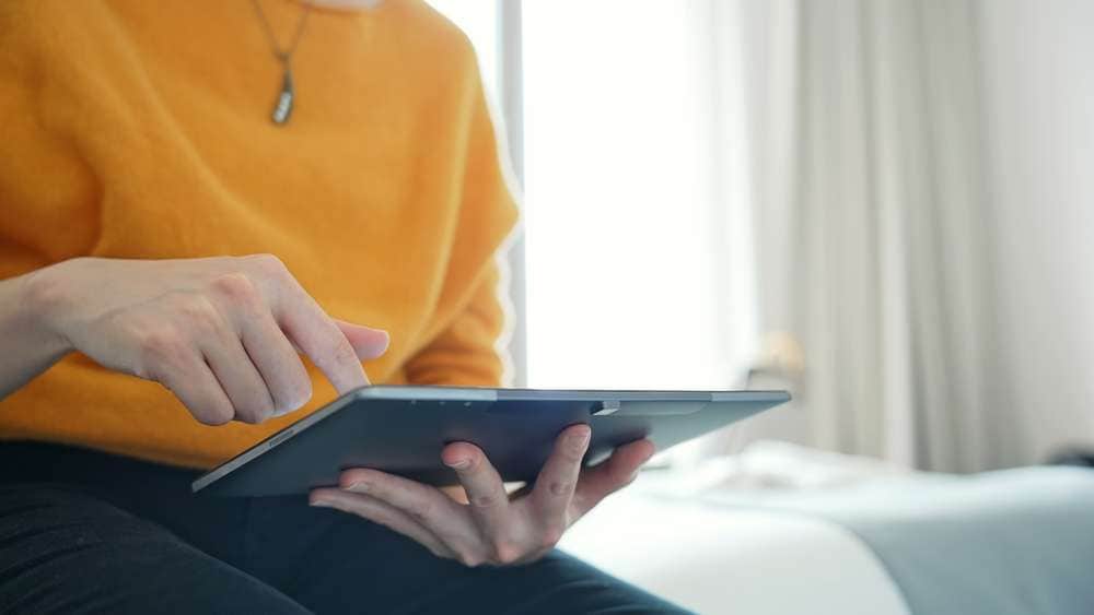 ホテルの客室でタブレット操作をする人