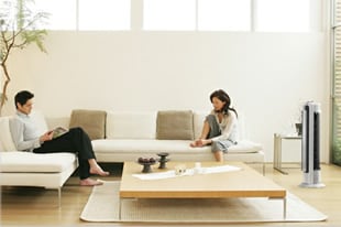 タワーファンがある部屋で夫婦がくつろいでいるシーン画像